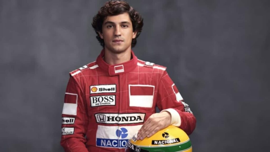Gabriel Leone, ator da série sobre Ayrton Senna na Netflix, sentado segurando o capacete do piloto, representando o ícone da Fórmula 1.