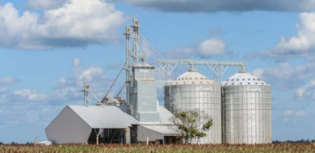 Armazéns e silos de grãos em uma propriedade rural, representando a infraestrutura do agronegócio sustentável e o armazenamento de produção agrícola.