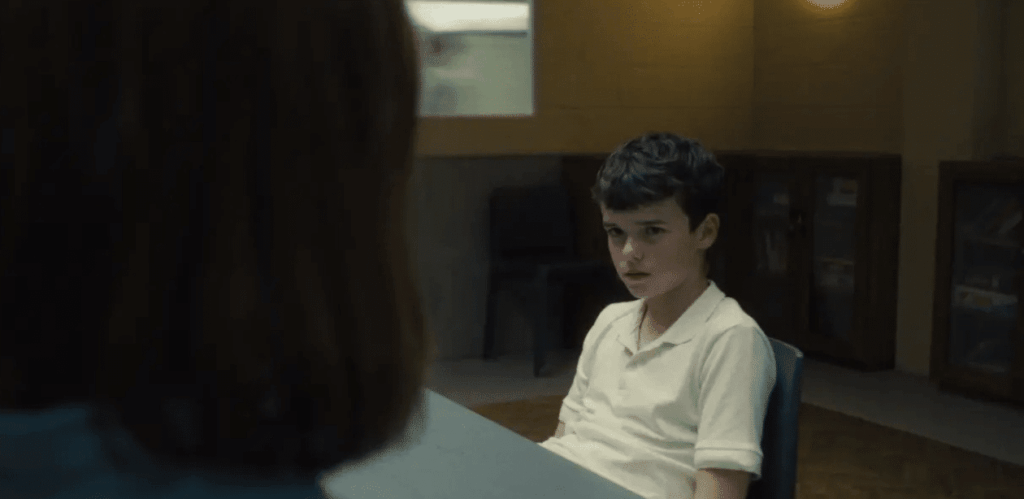 Cena da série Adolescência da Netflix mostra jovem em interrogatório, destacando impactos na saúde mental dos adolescentes.