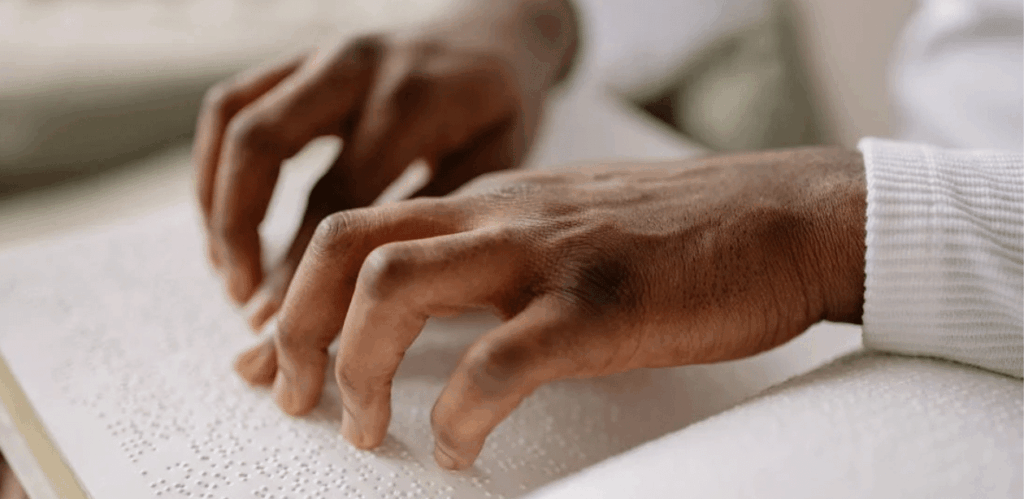 Mãos de pessoa lendo em Braille durante prova do Enem para deficientes visuais