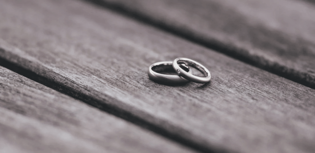 Alianças sobre madeira simbolizando casamento e relações afetivas na Atualização do Código Civil.