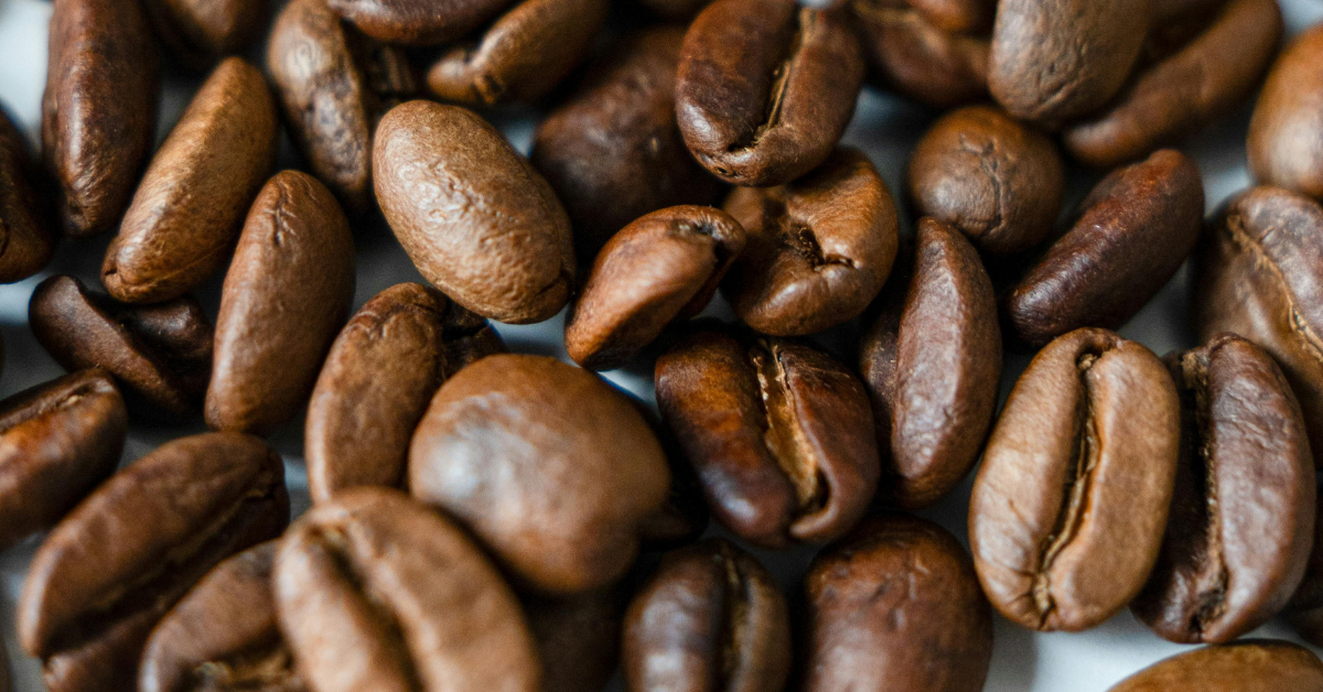 Grãos de café torrados espalhados sobre uma superfície.