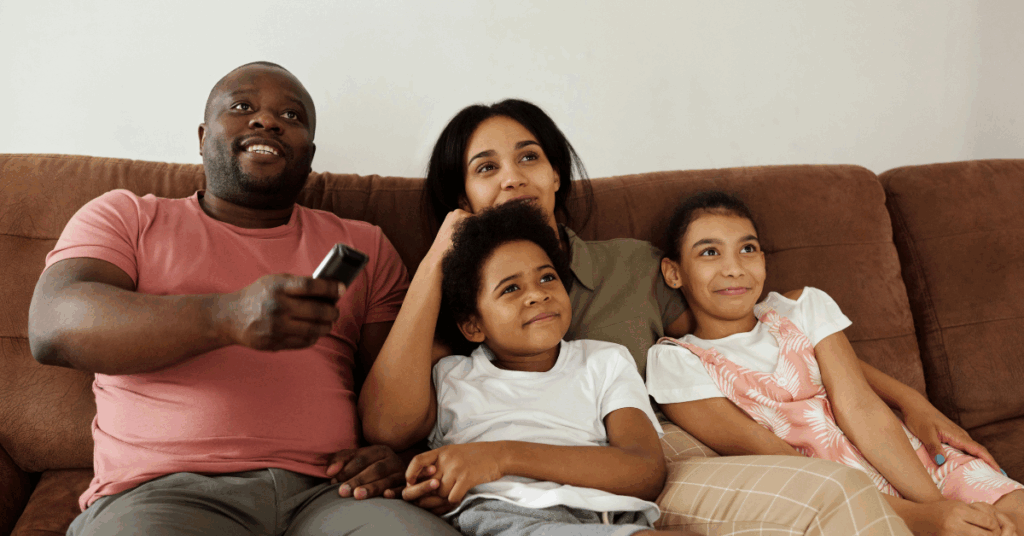 Família se divertindo assistindo séries no sofá