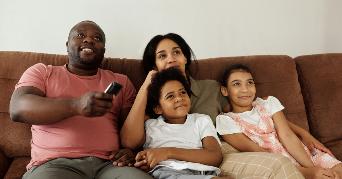 Família se divertindo assistindo séries no sofá
