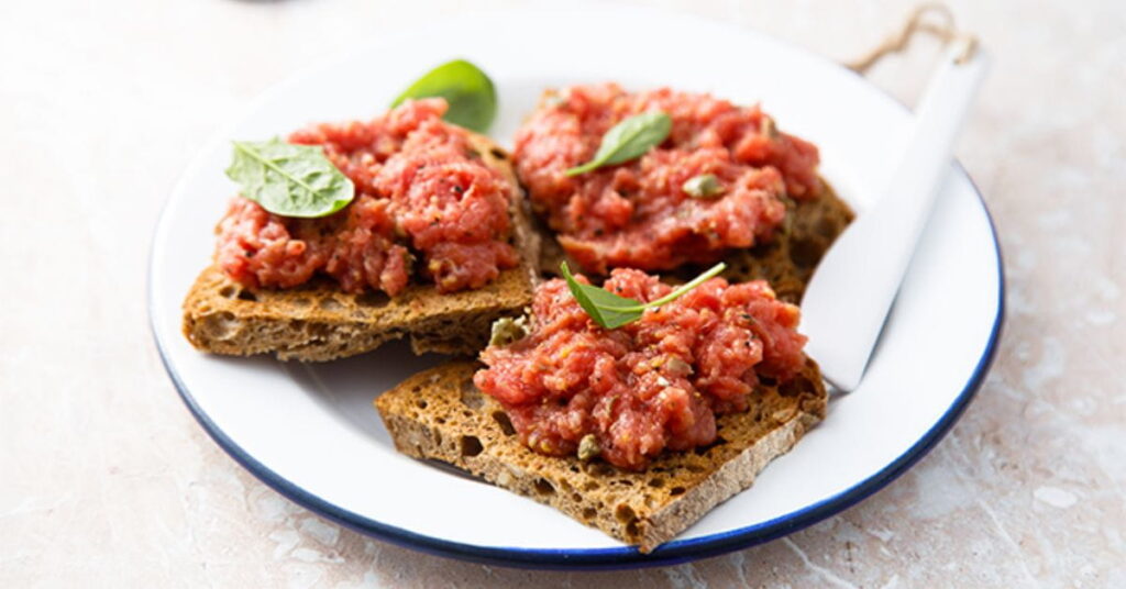 Carne de Onça servida sobre fatias de broa de centeio