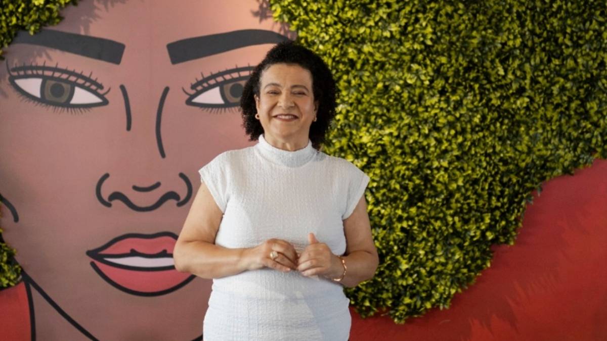 Ana Fontes posa diante de mural simbólico sobre o poder feminino, reforçando a trajetória de Ana Fontes no empreendedorismo.