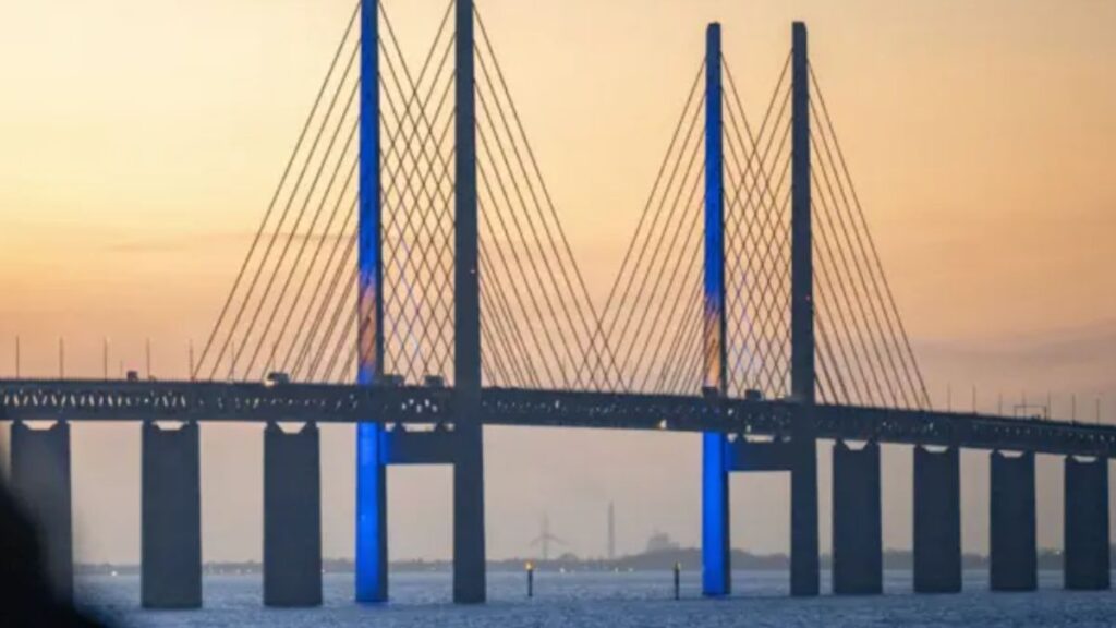 A Ponte de Öresund iluminada ao entardecer, símbolo de integração econômica e cultural entre Dinamarca e Suécia.