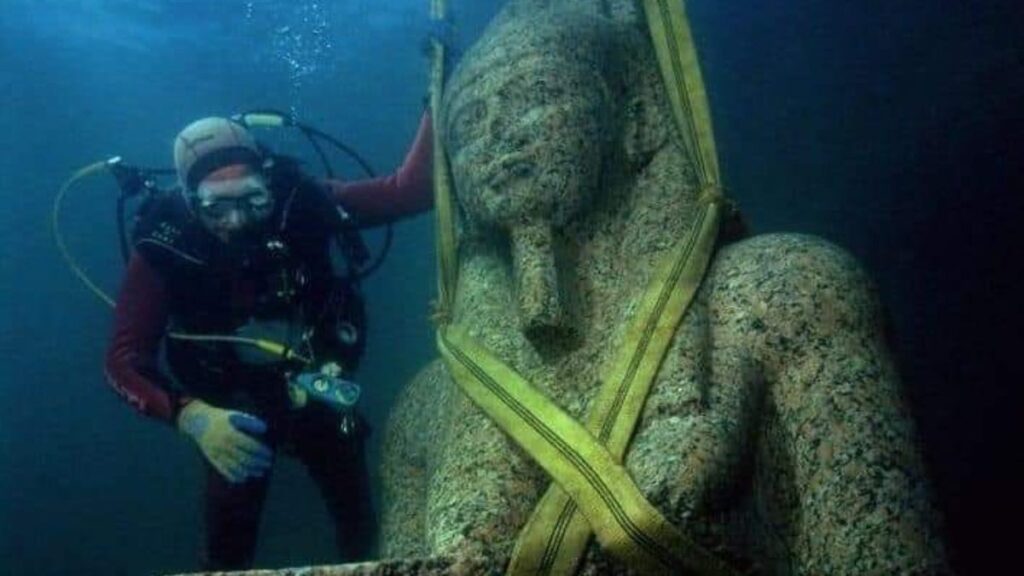 Mergulhador ao lado de estátua resgatada da cidade submersa em Alexandria, na baía de Abu Qir. - cidade submersa em Alexandria
