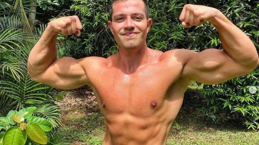 Giancarlo Eidler, treinador vegano, posa ao ar livre mostrando músculos definidos, exemplo de veganos musculosos que alcançam força com dieta vegetal.