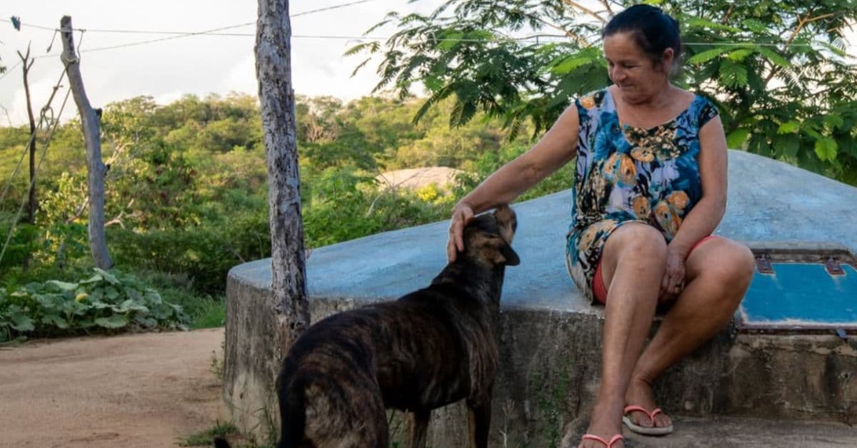 Mulher do Semiárido com cisterna ao fundo na Caatinga no debate climático