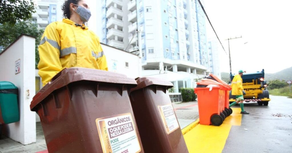Coleta seletiva de resíduos orgânicos em Florianópolis com lixeiras marrons.