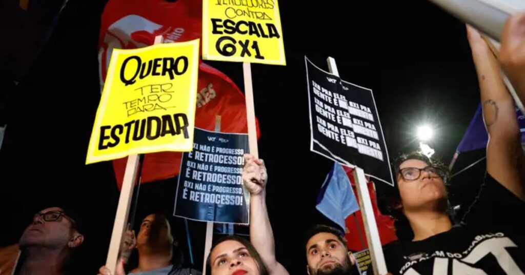 Fim da escala 6x1 - Manifestação contra a escala 6x1, com pessoas segurando cartazes. Um deles diz “Quero ter tempo para estudar” em letras grandes e outro traz a frase “6x1 não é progresso, é retrocesso”.