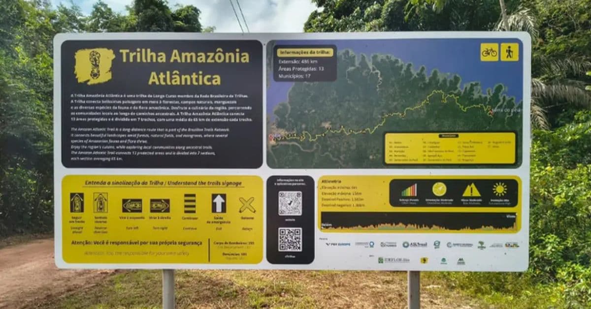 Placa informativa da Trilha Amazônia Atlântica, no Pará, com mapa do percurso e orientações para ciclistas e caminhantes.