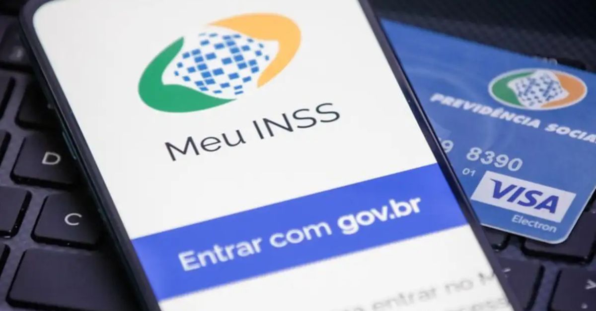 aplicativo Meu INSS aberto em celular sobre teclado.