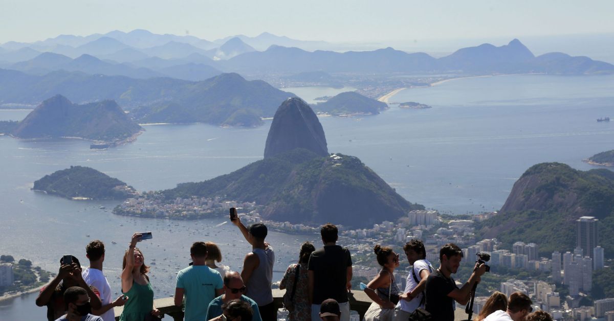 Imagem mostra turistas no Corcovado, no Rio de Janeiro.