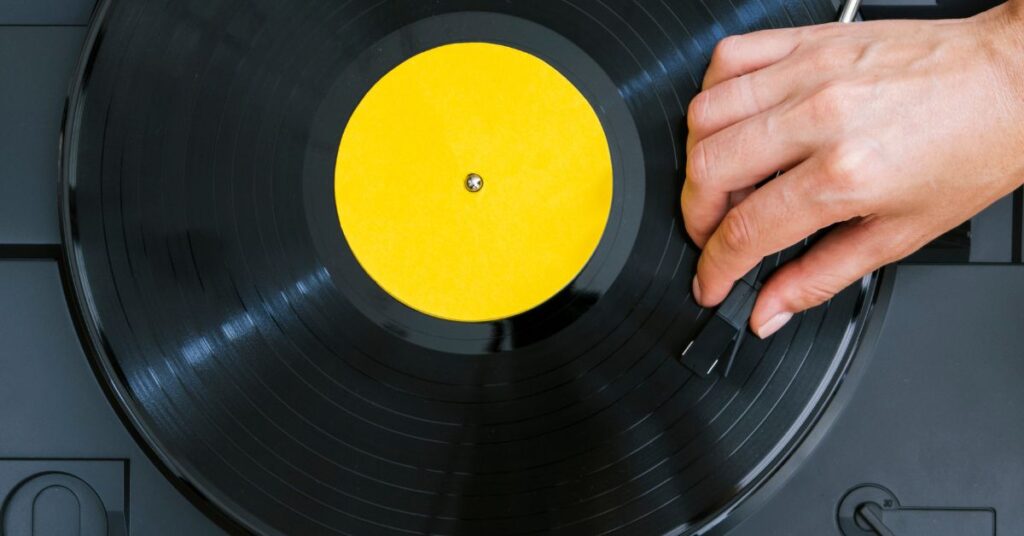 Volta do disco de vinil em toca-discos moderno sendo ajustado à mão