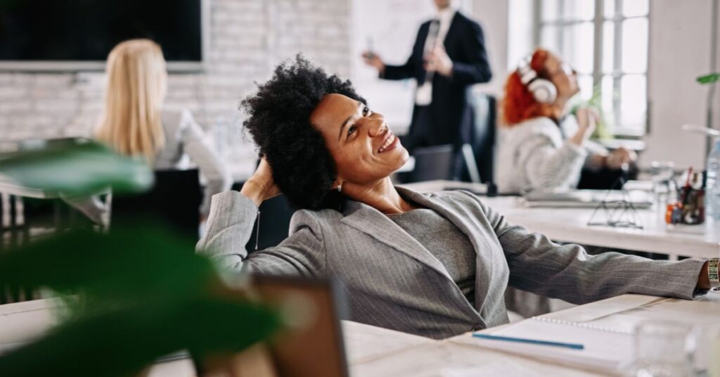 Profissional sorridente em ambiente de trabalho representando o bem-estar corporativo.