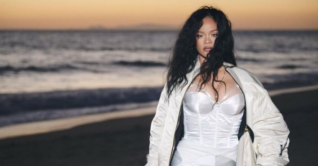 Conceito visual relacionado às Empresas bilionárias de Rihanna, mostrando figura feminina em cenário litorâneo ao entardecer.
