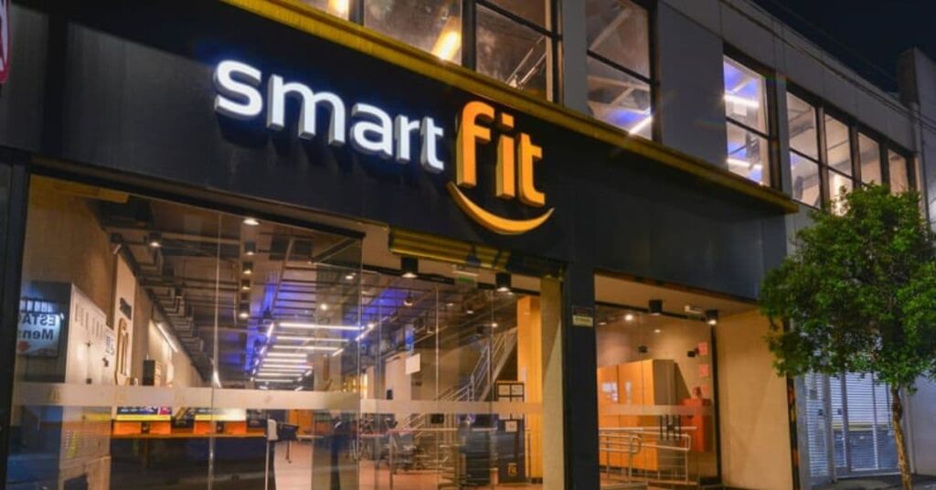 fachada iluminada de uma unidade da academia smart fit à noite