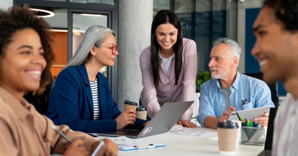 Etarismo no mercado de trabalho é superado por equipes com diversidade etária colaborando em ambiente corporativo