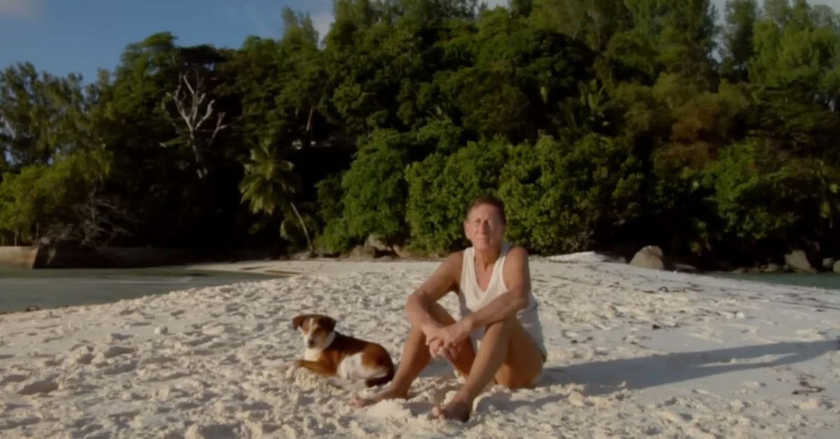 Homem sentado em praia de ilha restaurada após plantar 16 mil árvores em ilha deserta