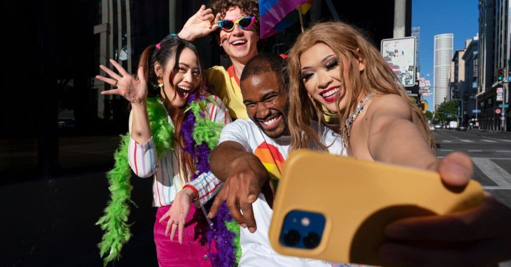 Data do carnaval de 2026 celebrada por grupo de foliões sorrindo e tirando selfie durante festa de rua colorida