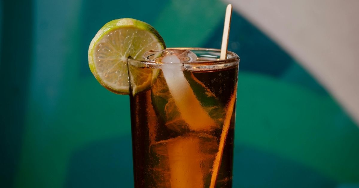 Parar de beber refrigerante representado por copo com gelo e limão sobre a mesa